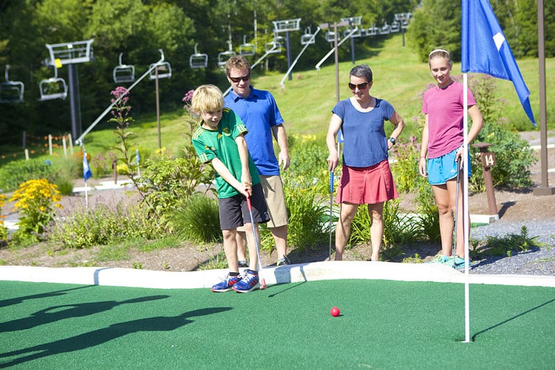 Family playing miniture golf.